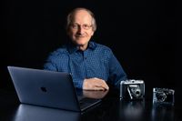 MG Fotografie | Portrait von einem Mann, im Vordergrund befinden sich ein Computer und Kameras